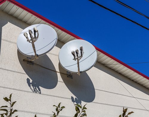 tv sattelites mounted to a house wall